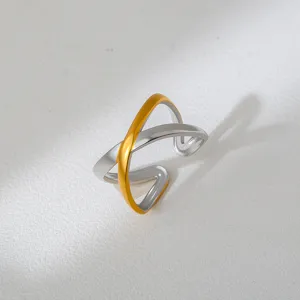 Detailed close-up of a two-tone cross open ring with sleek silver and gold finish.