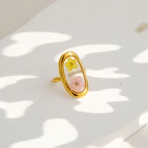 Close-up shot of the gold-plated stainless steel ring with transparent resin and floral detail.