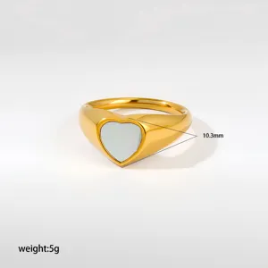 Primer plano del elegante anillo de acero inoxidable con corazón y acabado dorado brillante.