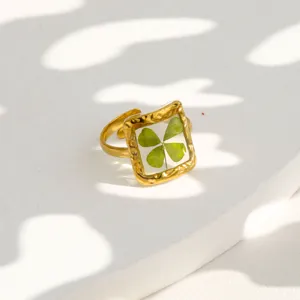 Detail view of gold plated stainless steel ring with transparent real four leaf clover resin.
