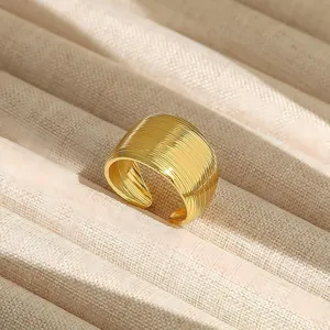Exquisito anillo dorado ancho con diseño acanalado moderno, detalle elegante de joyería en cobre.