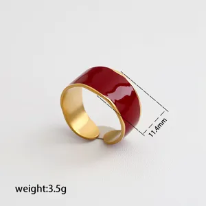 Anillo abierto ancho de acero inoxidable con esmalte rojo y borde dorado, elegante.