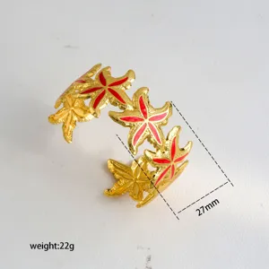 Gold starfish cuff detail view, red enamel inlay, open bracelet closeup showing 27mm size.
