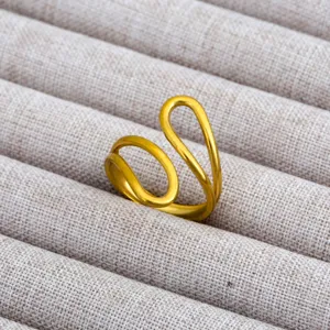 Primer plano de anillo abierto dorado, diseño geométrico minimalista, elegante joya expuesta.