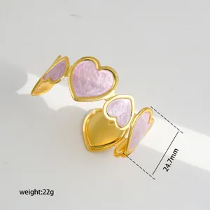 Gold C-shaped open cuff bracelet with pink enamel hearts, elegant fashion jewelry.