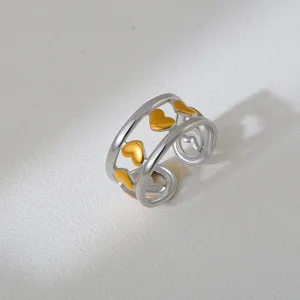 Close-up of a trendy two-tone stainless steel open ring featuring cute gold heart motifs.