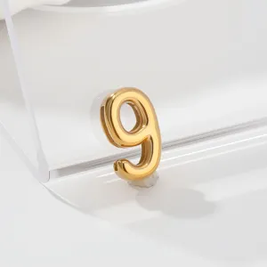 Detail view of a shiny gold metallic number 9 pendant charm for custom jewelry making.