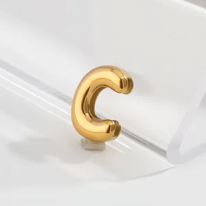 Close-up of a gold stainless steel letter C charm pendant, featuring a smooth glossy finish.