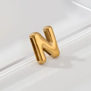 Close-up detail of shiny gold puffy letter N pendant showing smooth metallic gloss texture.