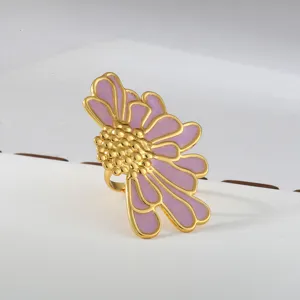 Close-up detail of a stylish stainless steel gold flower ring with purple enamel petals.