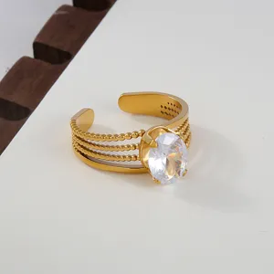 Detail shot of a multi-band gold stainless steel open ring featuring an oval cubic zirconia.