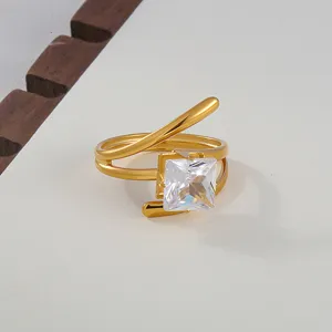 Close-up of golden open stainless steel ring featuring a sparkling square cubic zirconia stone.