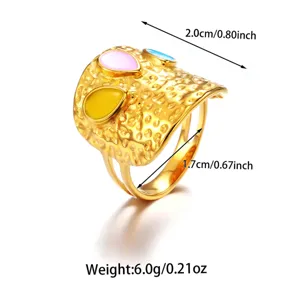 Gedetailleerd overzicht van brede gouden roestvrijstalen open ring met kleurrijke druppel.