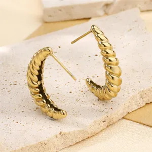 Gros plan de boucles d'oreilles créoles torsadées en acier inoxydable plaqué or 18k.