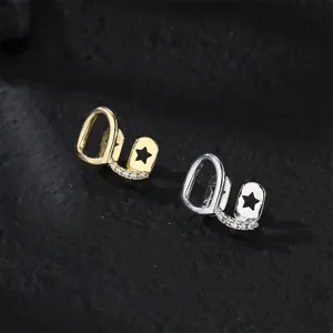 Hip hop grillz set featuring hollow star design and sparkly cubic zirconia in gold and silver.
