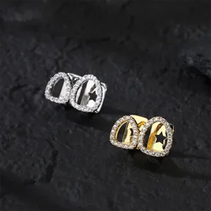Closeup of hip hop grillz tooth caps, copper paved cubic zirconia with star hollow detail.