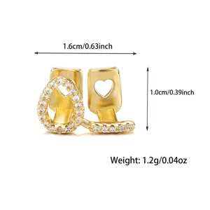 Gold iced out grillz tooth cap detail shot with heart cutout and sparkling cubic zirconia stones.