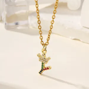 Dettaglio della collana con ciondolo lettera Y e corona con zirconi multicolori oro.