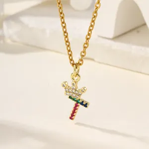 Primo piano dettagliato di una collana con ciondolo a lettera e corona in zirconi multicolore.