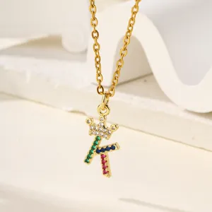 Dettaglio della collana con ciondolo lettera corona dorata, design microincastonato.
