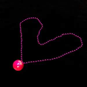 Detailopname van lichtgevende ketting met roze kralenketting en disco bal hanger.