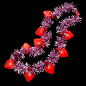 Nahaufnahme Detail der leuchtenden Herz-Halskette mit rosa Lametta und roten LEDs.