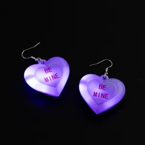Orecchini a cuore LED viola dettaglio primo piano, bellissimi gioielli luminosi per feste.