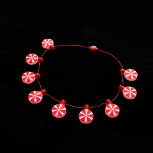Close-up details of the Christmas glowing candy pendant necklace, showing red and white design.