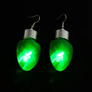 Nahaufnahme leuchtender grüner Glühbirnen-Ohrringe mit silbernem Haken, Party-Schmuck.