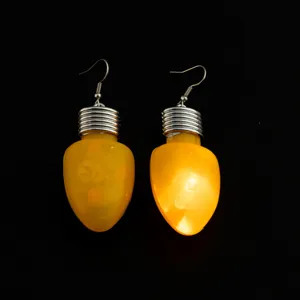 Nahaufnahme von leuchtenden gelben Glühbirnen Ohrringen, weihnachtlicher Festschmuck Detail.