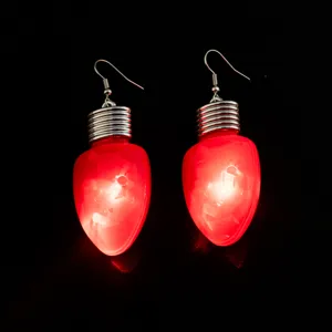 Detailansicht leuchtender roter Weihnachtsbirnen-Ohrringe, einzigartiges Feiertags-Schmuck-Design.
