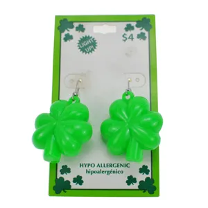 Boucles d'oreilles lumineuses trèfle vert sur carte saint patrick, bijoux de fête parfaits.