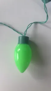 Close-up detail of a bright green Christmas bulb with matching wire for holiday decor.