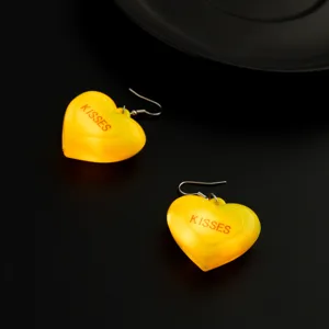 Vista dettagliata di orecchini luminosi a cuore giallo con LED per feste alla moda.