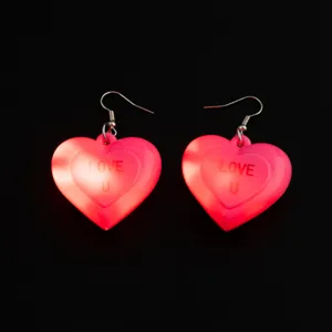 Primo piano dettagliato di orecchini pendenti a cuore luminosi, perfetti gioielli LED per feste.