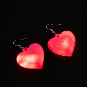 Primo piano degli orecchini a cuore luminosi rosa, che mostrano l'illuminazione a LED e dettagli.
