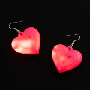Dettaglio di orecchini a cuore rosa luminosi con luci LED per feste di San Valentino.