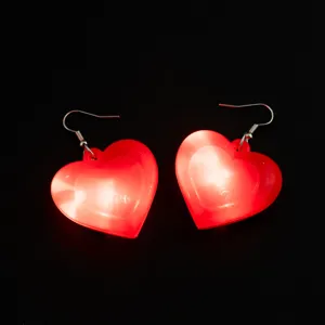 Orecchini pendenti a cuore luminoso a LED rosso dettaglio primo piano per gioielli festa