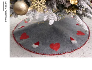 Détail de jupe de sapin de Noël en feutre gris avec cœurs rouges et bonnets de lutin.