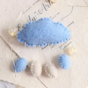 Adorable ornement suspendu en feutre bleu en forme de nuage avec des gouttes de pluie.