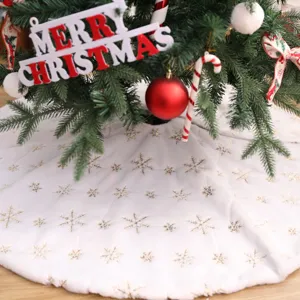 Jupe de sapin de Noël en peluche blanche avec flocons de neige dorés pour décoration.