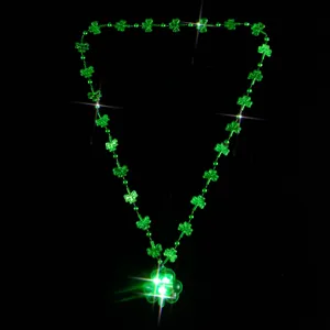 Nahaufnahme der leuchtenden grünen Kleeblatt LED Perlenkette, perfektes Festtags Schmuck Detail.