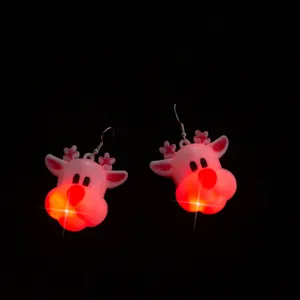 Primo piano dettagliato di orecchini natalizi a forma di renna luminosa LED al buio.