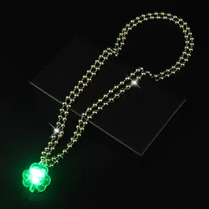 Detail shot of the glowing green clover LED necklace, showing bright festival party lighting.