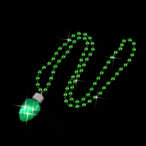 Green lightbulb pendant necklace detail shot, glowing LED bulb with green beaded chain.