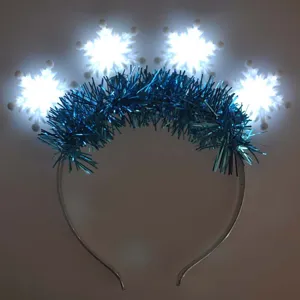 Close-up detail shot of glowing snowflake headband featuring blue tinsel and bright LED lights.