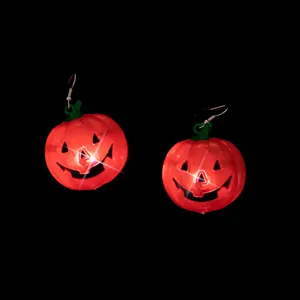 Close up of glowing Halloween pumpkin earrings featuring LED lights and spooky festive design.
