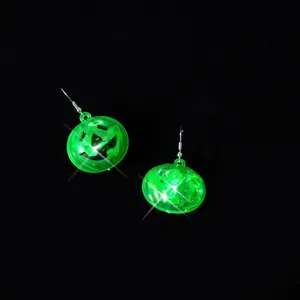 Detailansicht grüne LED Halloween Kürbis Ohrringe, leuchtende Plastik Ohrhänger Nahaufnahme.