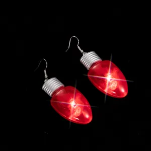 Boucles d'oreilles ampoule lumineuse rouge gros plan, bijoux LED de Noël festifs, détail.