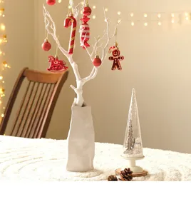 Christmas tabletop decoration set with white ceramic vase and red ornaments for holiday home decor.